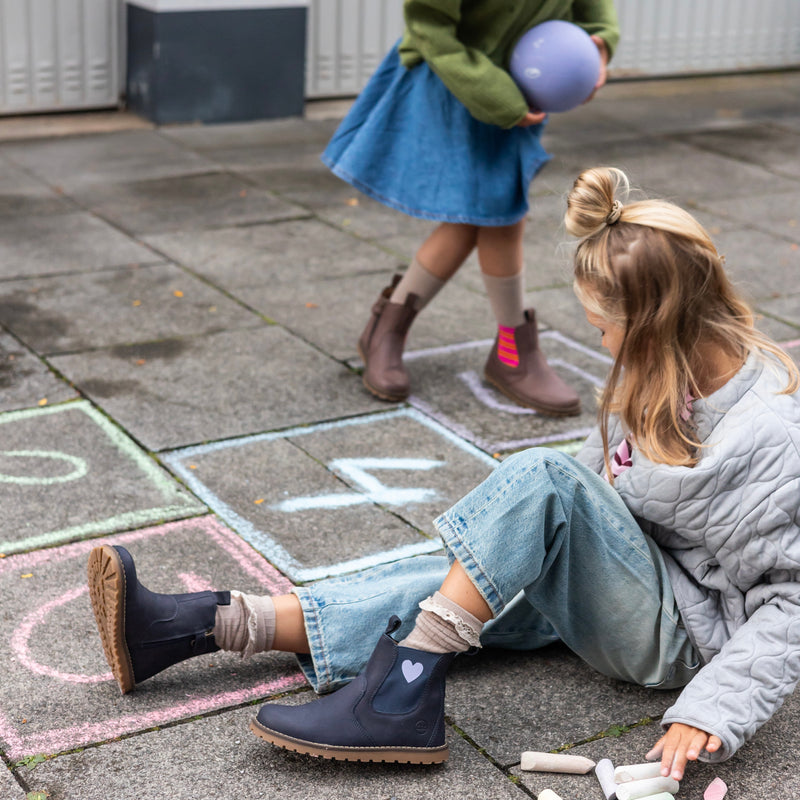Child wearing the Chelsea Boot in pink and orange outdoors