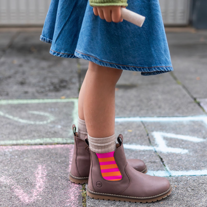 Close-up of the pink and orange striped elastic panel on the Chelsea Boot, worn on a chalk hopscotch grid