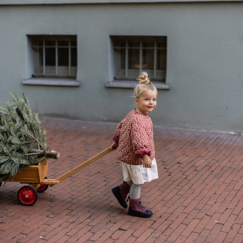 Toddler in the berry First Step Finn pulling a wooden cart