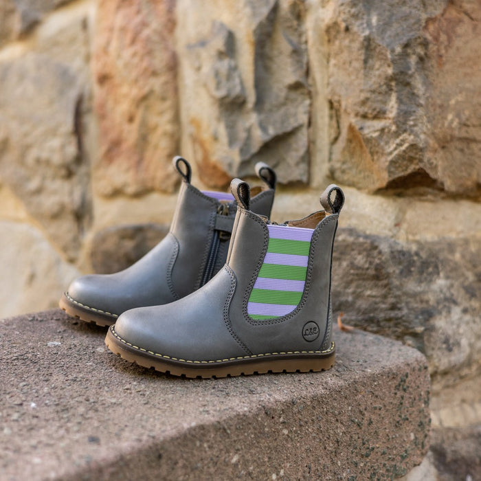 Lilac and green Chelsea boots on a stone step