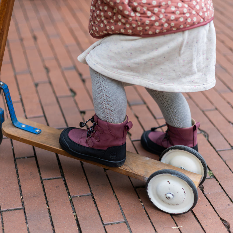 Child wearing the First Step Finn in berry