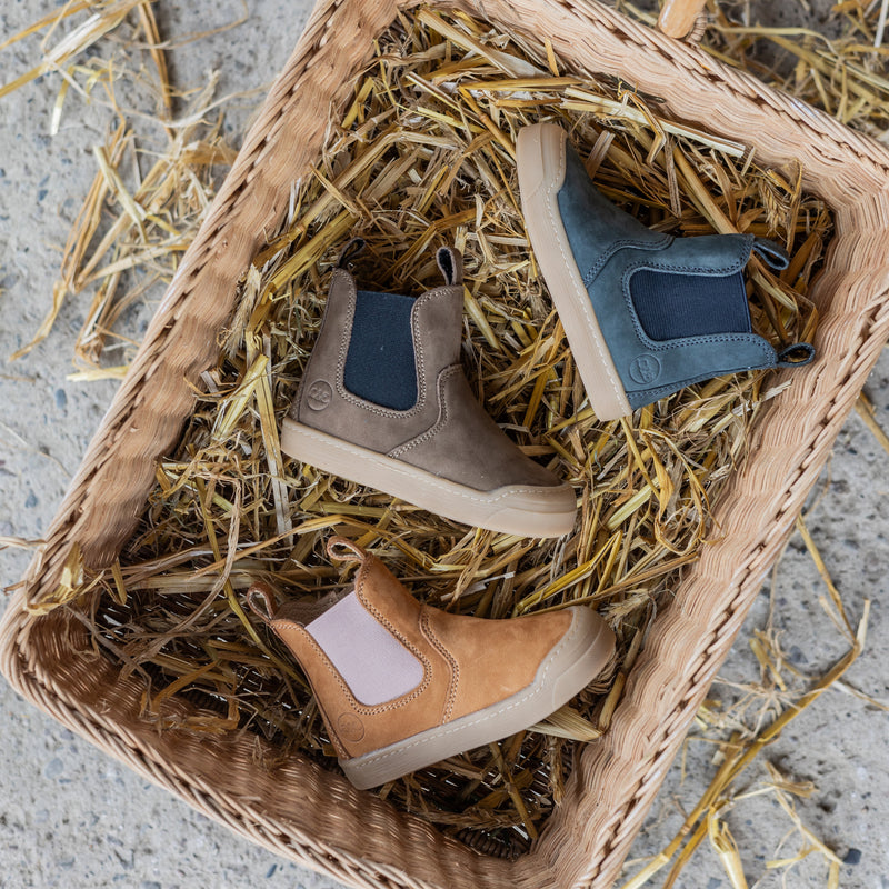 Winter Janne Booties in several colors resting in a straw basket
