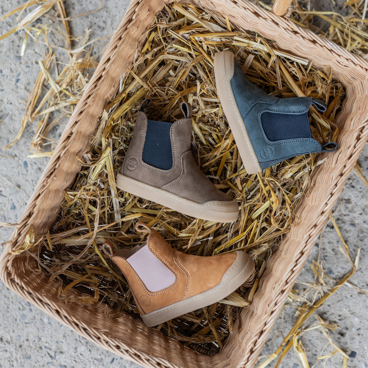 Winter Janne Booties in several colors resting in a straw basket
