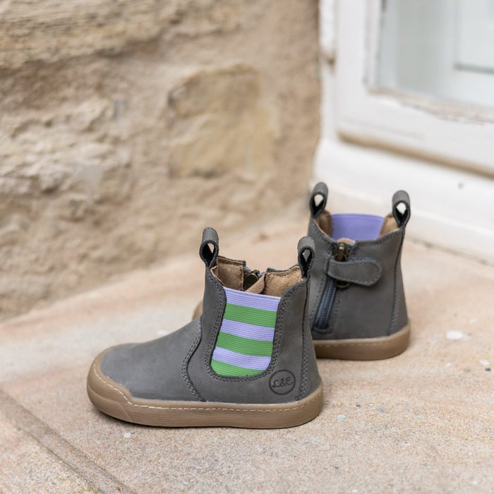 Janne bootie with a lilac and green striped panel on a stone step